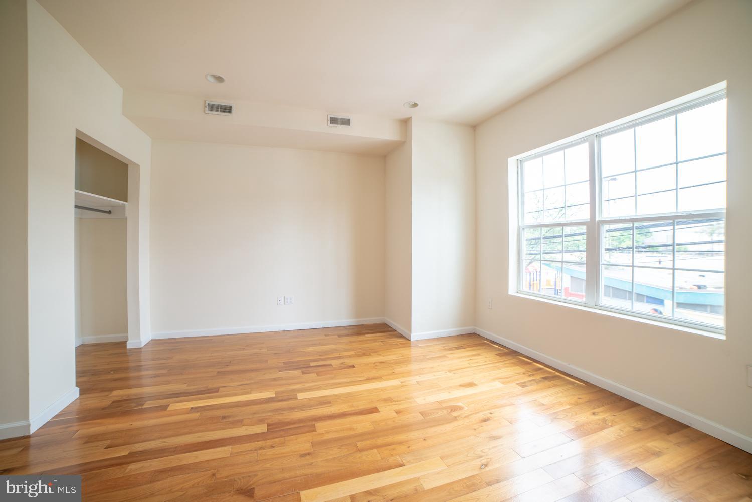 1830 North 16th Street, Unit 2 Philadelphia, PA 19121 - Photo 2 of 19 a view of an empty room with wooden floor and a window