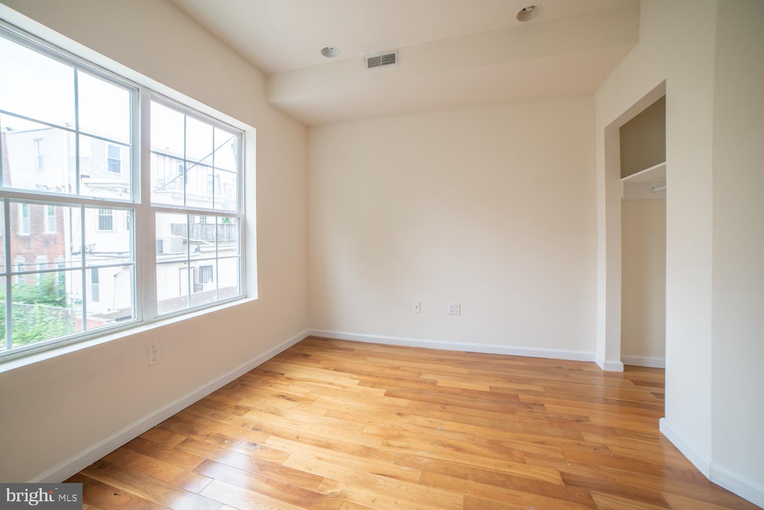 1830 North 16th Street, Unit 2 Philadelphia, PA 19121 - Photo 4 of 19 a view of an empty room with wooden floor and a window