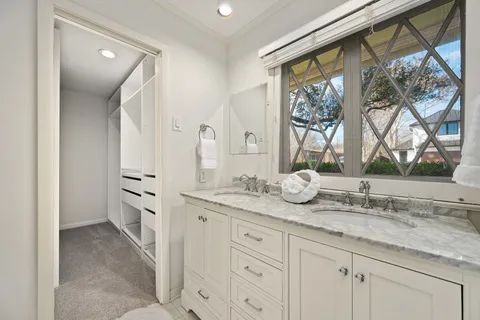 a bathroom with a granite countertop sink mirror and window