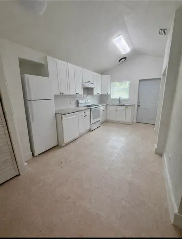 a kitchen with white cabinets and white appliances