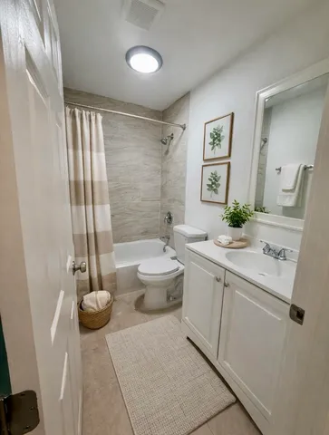 a spacious bathroom with a granite countertop sink a toilet and a mirror