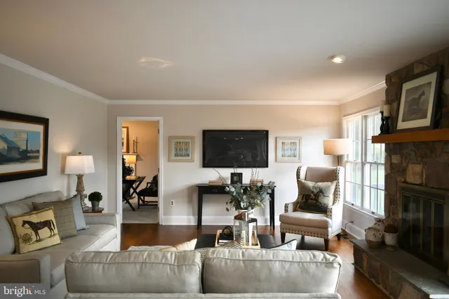 a living room with furniture a flat screen tv and a fireplace