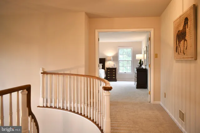 a view of a hallway view with a wooden floor and a bathroom