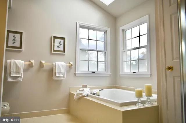 a bathroom with a tub sink and mirror