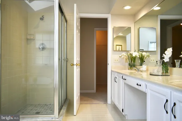 a bathroom with a double vanity sink mirror and shower