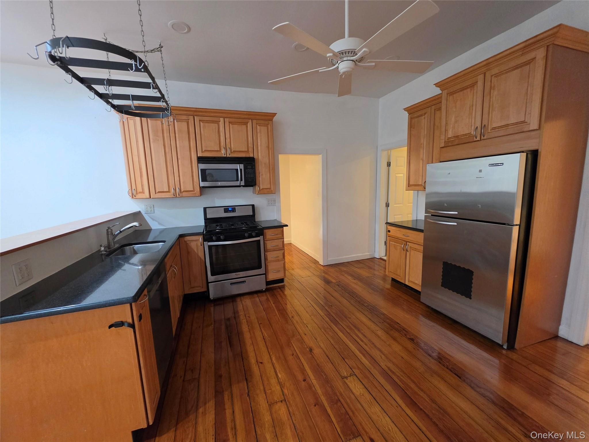 60 Main Street Tappan, NY 10983 - Photo 7 of 22 a kitchen with granite countertop a refrigerator a stove a sink and dishwasher with wooden floor