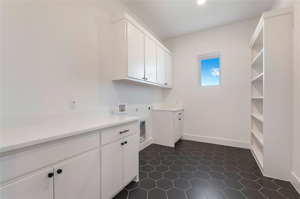 430 Whispering Way Red Oak, TX 75154 - Photo 23 of 40 Laundry room featuring hexagonal floor tiles, extensive white cabinetry, white countertops, built-in shelving, and a single window