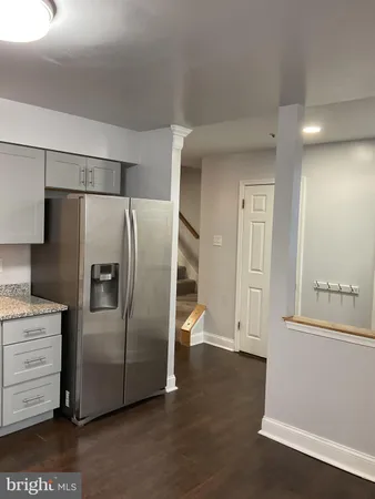 an empty room with wooden floor and mirror
