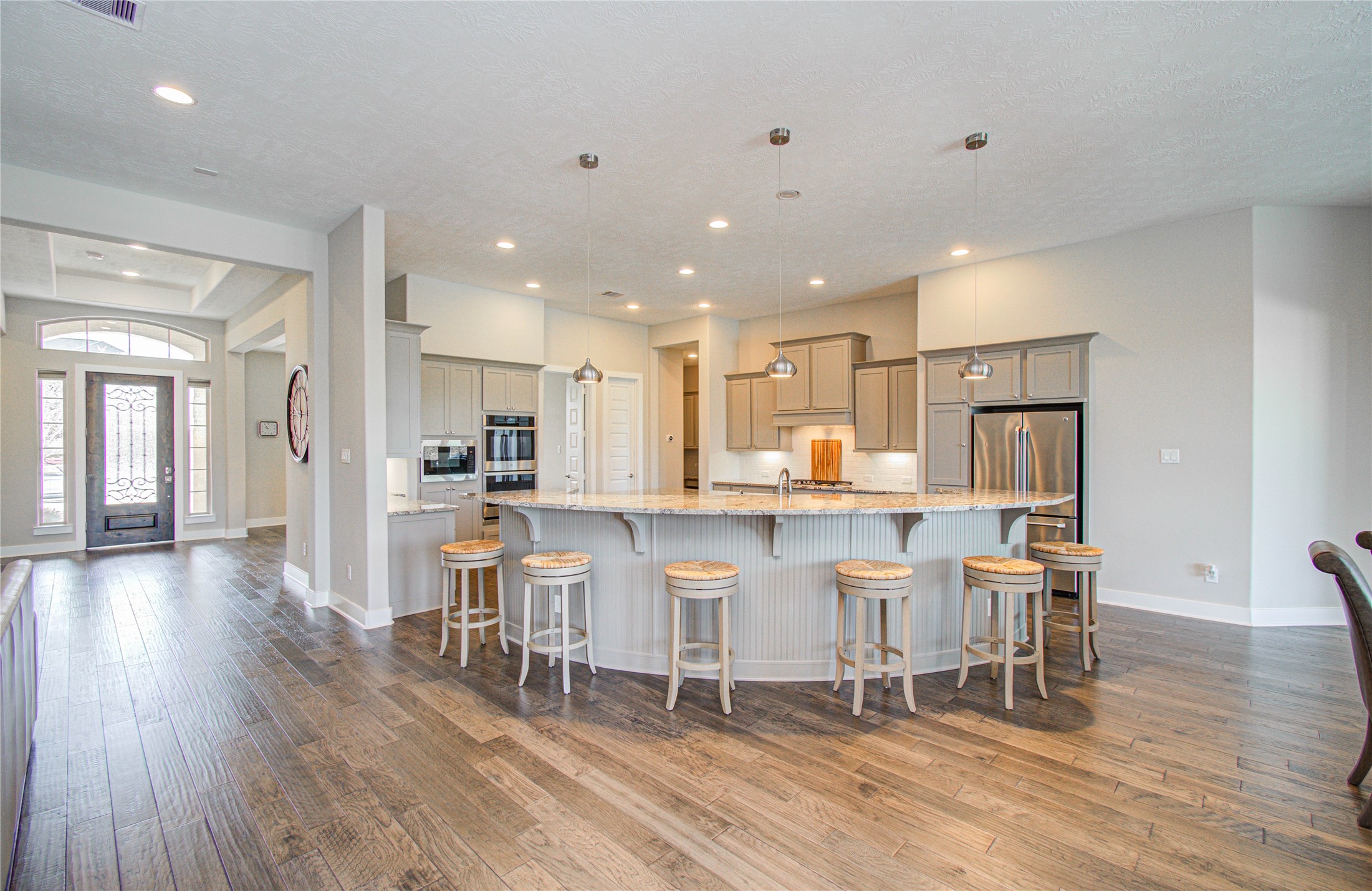 29702 Hay Field Lane Fulshear, TX 77406 - Photo 16 of 45 a kitchen with a dining table chairs wooden floor cabinets and a refrigerator