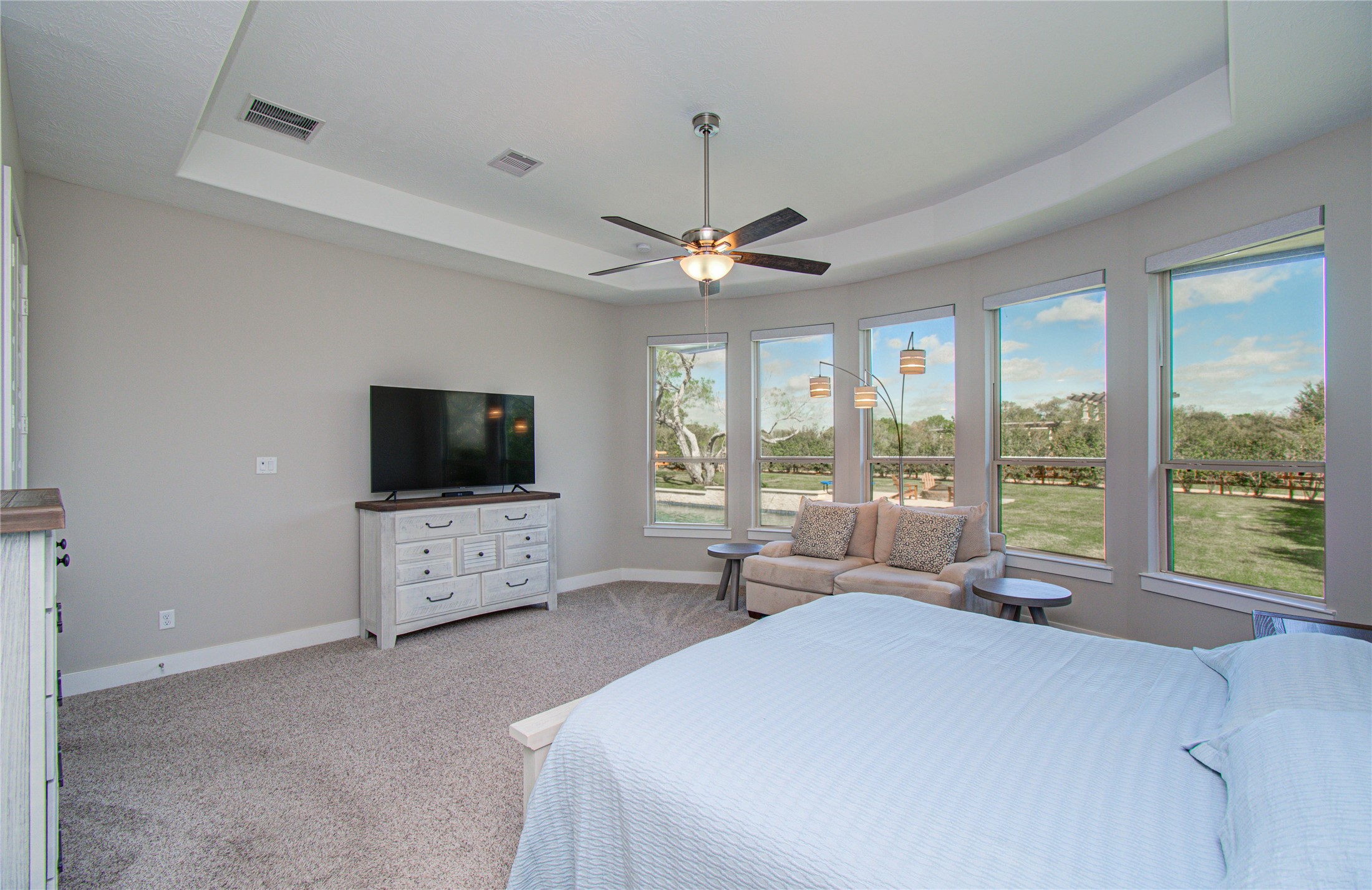 29702 Hay Field Lane Fulshear, TX 77406 - Photo 22 of 45 a large bedroom with a large bed and a flat tv screen on dresser