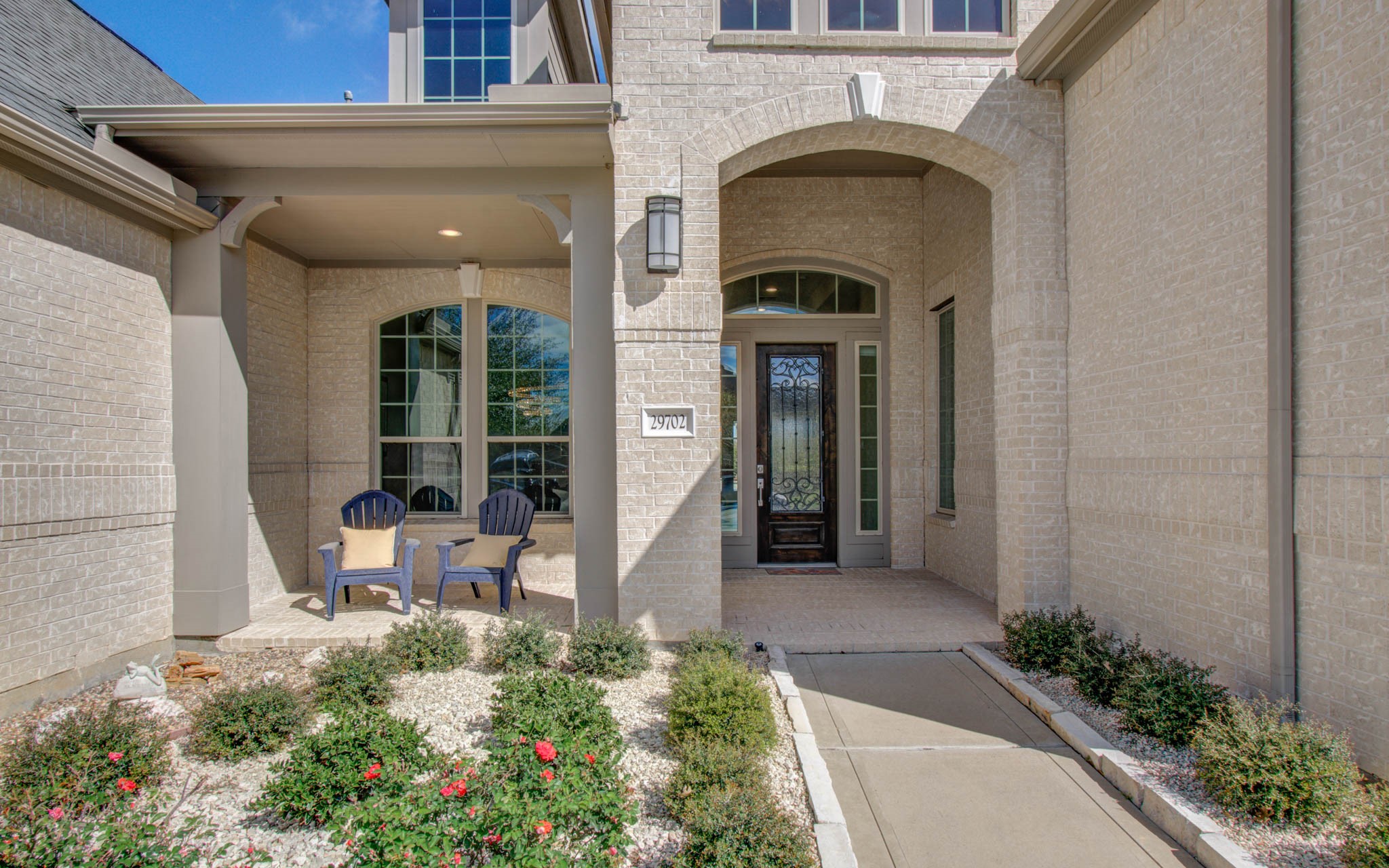 29702 Hay Field Lane Fulshear, TX 77406 - Photo 4 of 45 a front view of a house with outdoor seating and flower plants