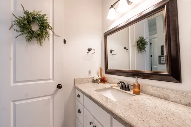 a bathroom with a granite countertop sink a mirror and a shower