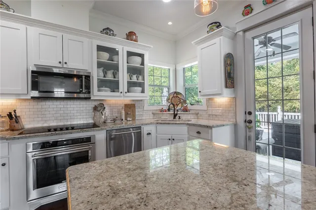 a kitchen with stainless steel appliances granite countertop a stove sink microwave and refrigerator