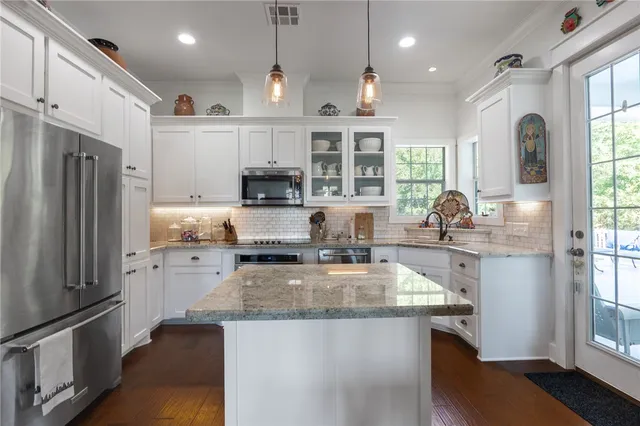 a kitchen with stainless steel appliances granite countertop a sink stove and refrigerator
