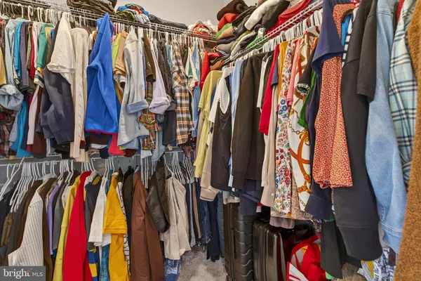 a view of walk in closet with clothes
