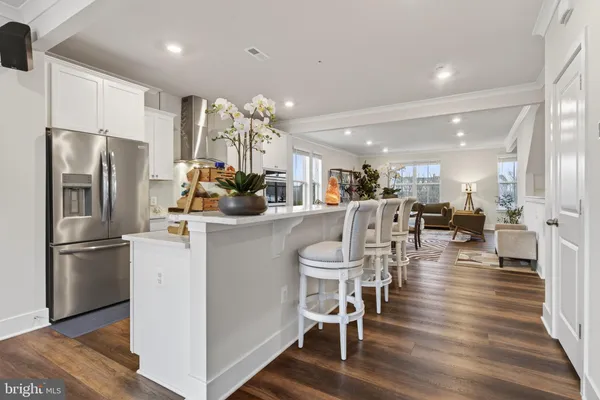 a kitchen with a refrigerator a dining table and chairs