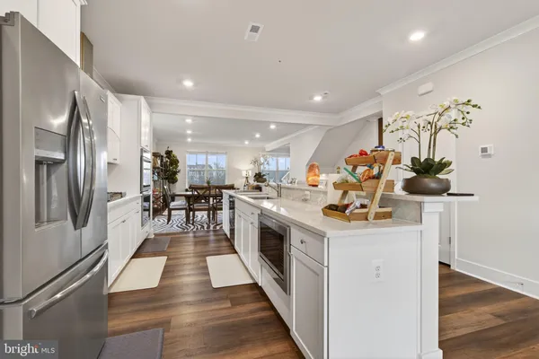 a kitchen with stainless steel appliances granite countertop a sink and a refrigerator