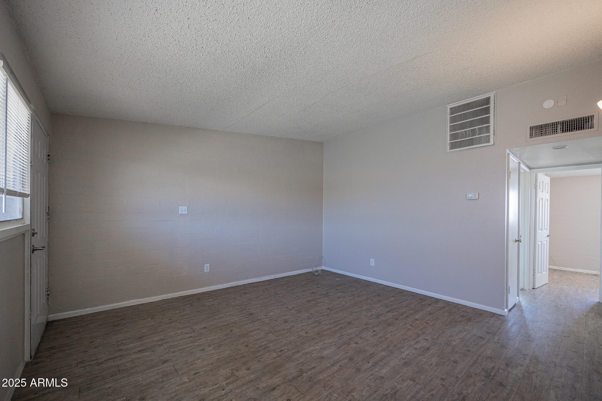 2139 West Devonshire Avenue, Unit 4 Phoenix, AZ 85015 - Photo 6 of 13 an empty room with wooden floor and windows