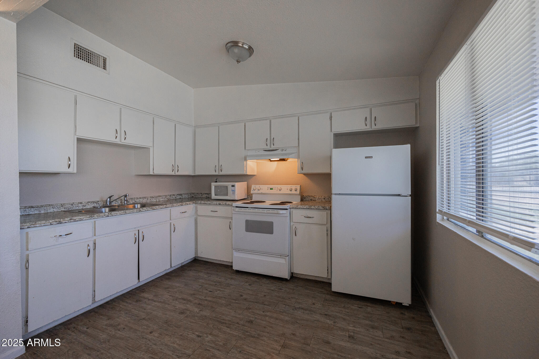2139 West Devonshire Avenue, Unit 4 Phoenix, AZ 85015 - Photo 7 of 13 a kitchen with granite countertop white cabinets and white appliances
