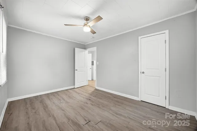 a view of an empty room with wooden floor