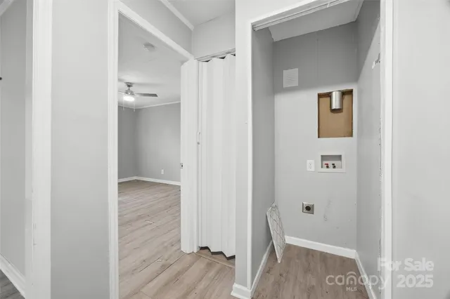 a view of a hallway with wooden floor and closet area