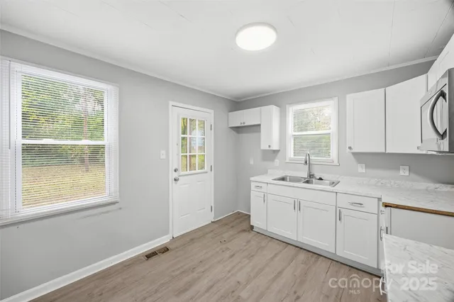 a room with a sink cabinets and a window