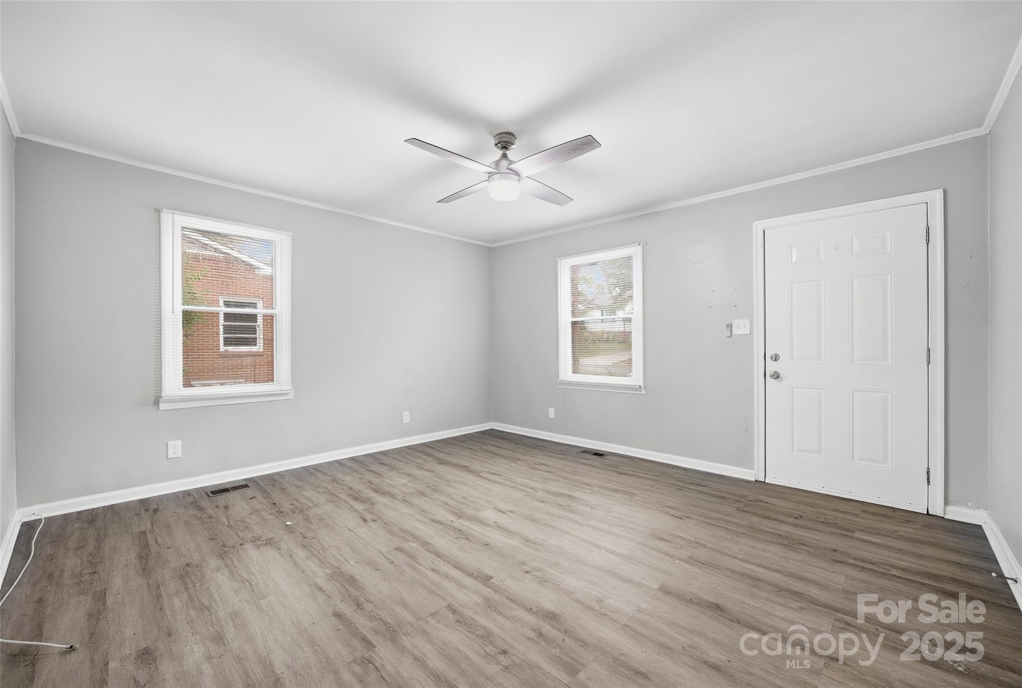 126 South Jackson Road Lancaster, SC 29720 - Photo 19 of 24 an empty room with wooden floor ceiling fan and windows