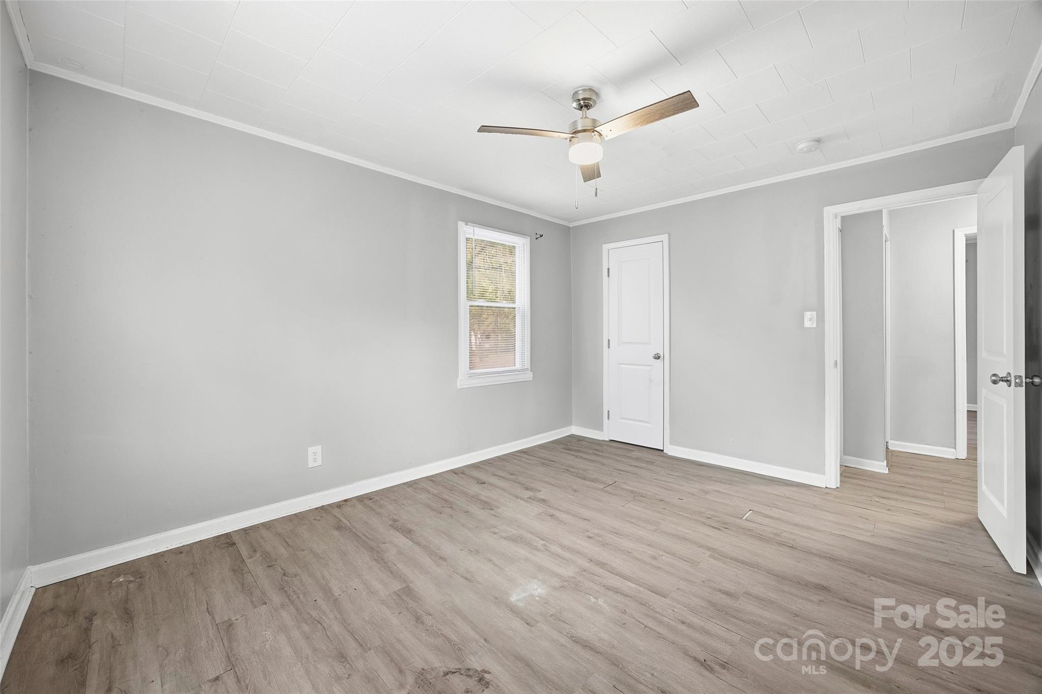 126 South Jackson Road Lancaster, SC 29720 - Photo 10 of 24 an empty room with wooden floor ceiling fan and windows