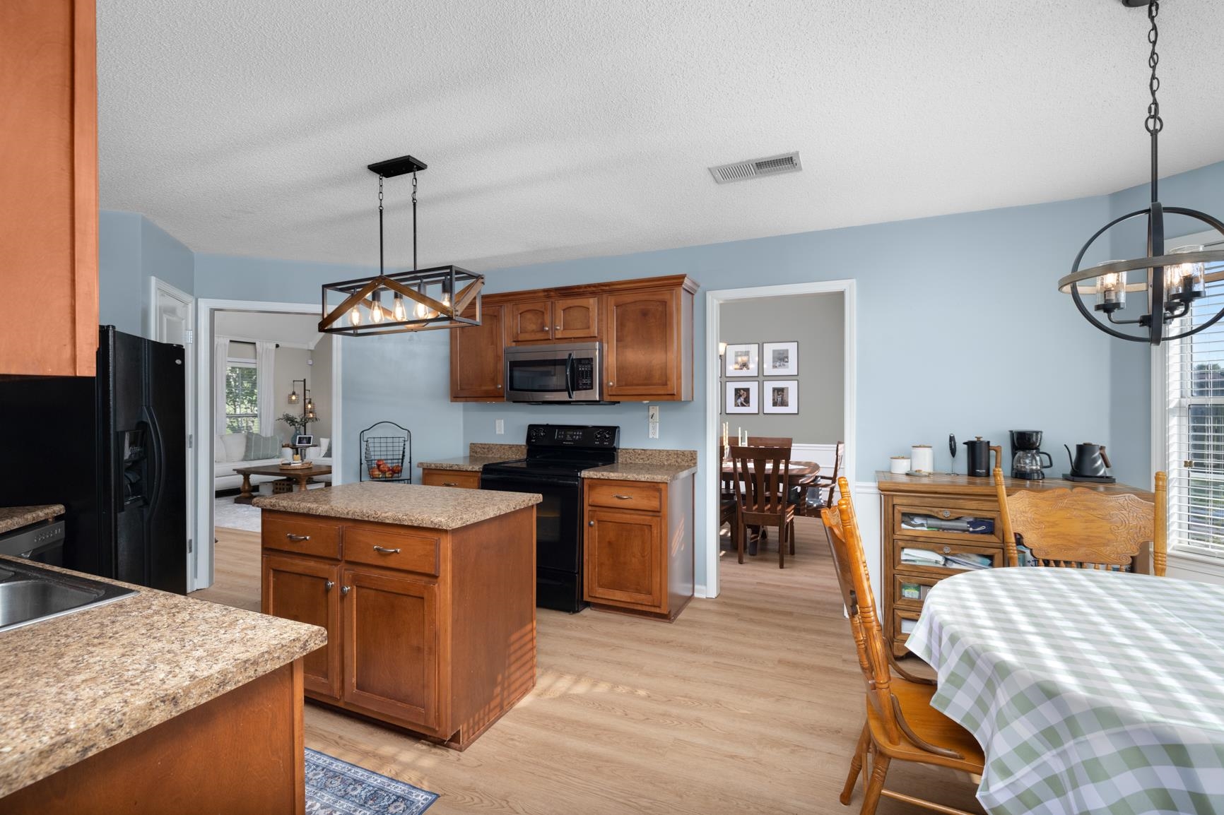 505 Terry Road Oakland, TN 38060 - Photo 19 of 40 Kitchen featuring a chandelier, brown cabinetry, hanging light fixtures, and a textured ceiling