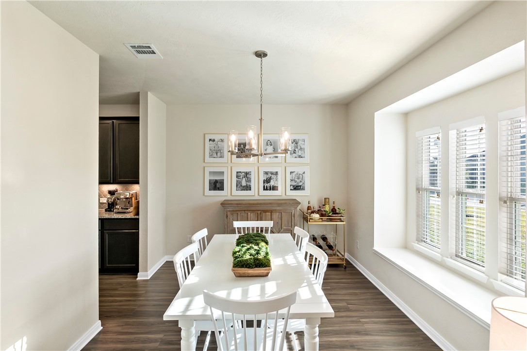 1310 Kingsgate Drive Bryan, TX 77807 - Photo 12 of 24 Dining space with a chandelier and dark wood-style flooring