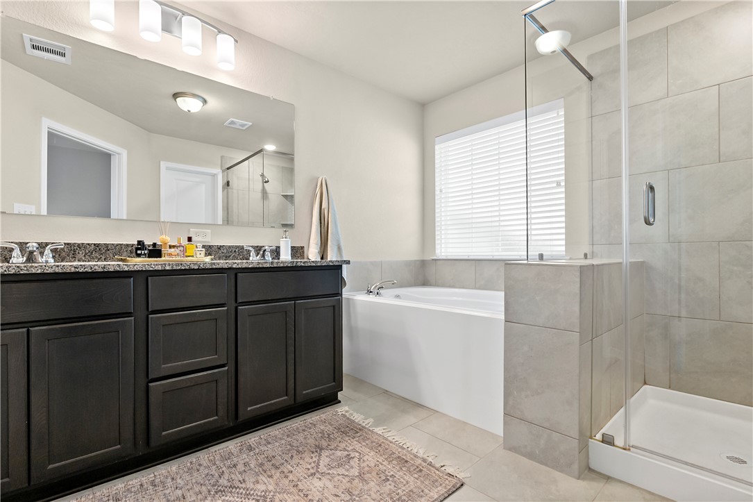 1310 Kingsgate Drive Bryan, TX 77807 - Photo 16 of 24 Bathroom featuring a garden tub, a shower stall, double vanity, and light tile patterned flooring