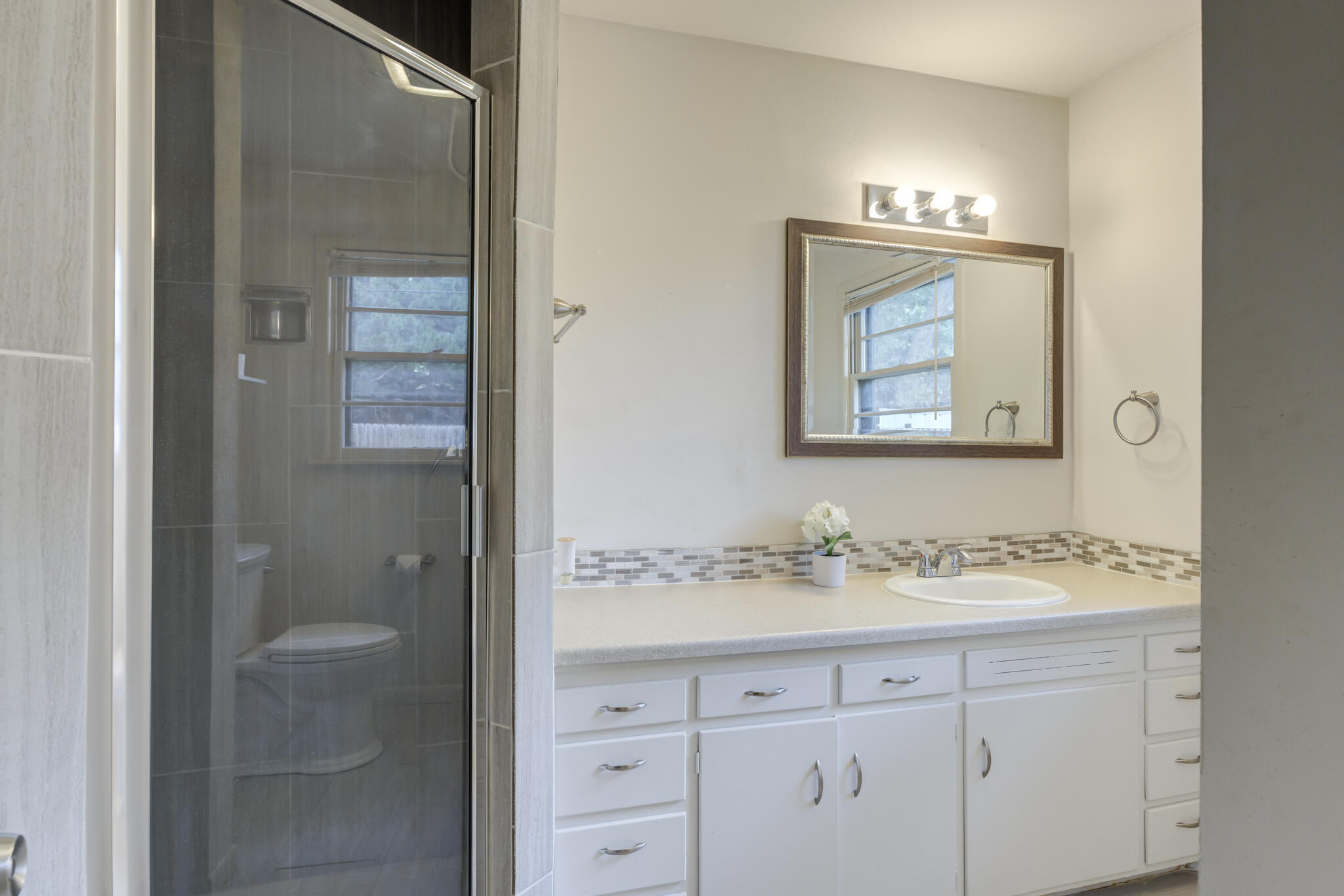 3614 45th Street Lubbock, TX 79413 - Photo 17 of 38 a bathroom with a sink vanity and a mirror