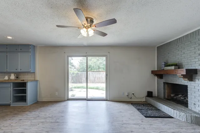 a view of a livingroom with furniture a ceiling fan and wooden floor