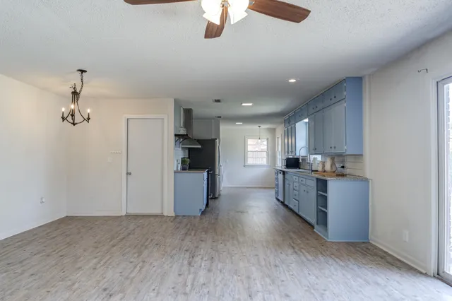 a view of empty room with wooden floor and ceiling fan