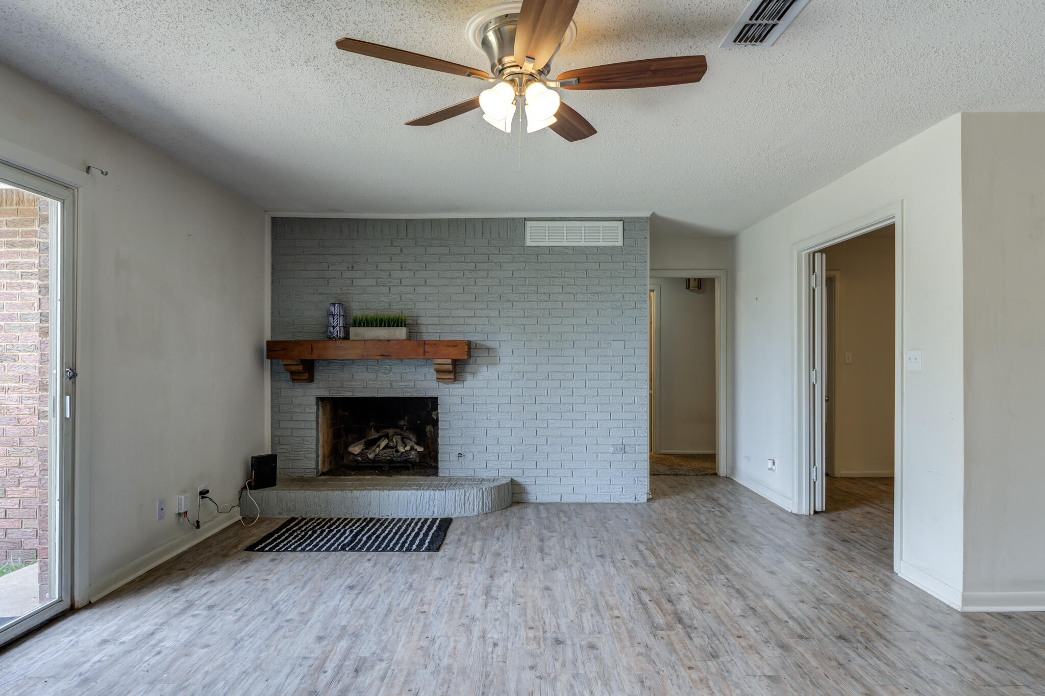 3614 45th Street Lubbock, TX 79413 - Photo 23 of 38 an empty room with a fireplace and a window