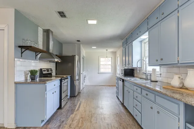 a kitchen with white cabinets and sink