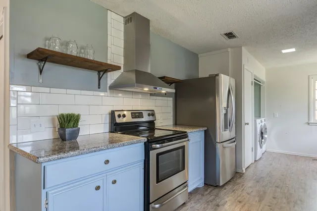 a stove top oven sitting inside of a kitchen