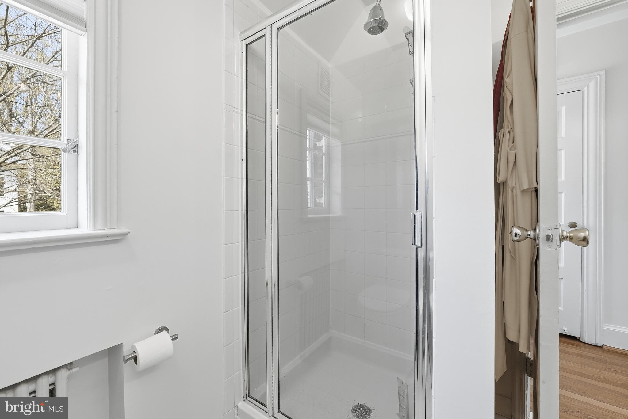 4938 Quebec Street Northwest Washington, DC 20016 - Photo 27 of 51 a bathroom with a glass shower door