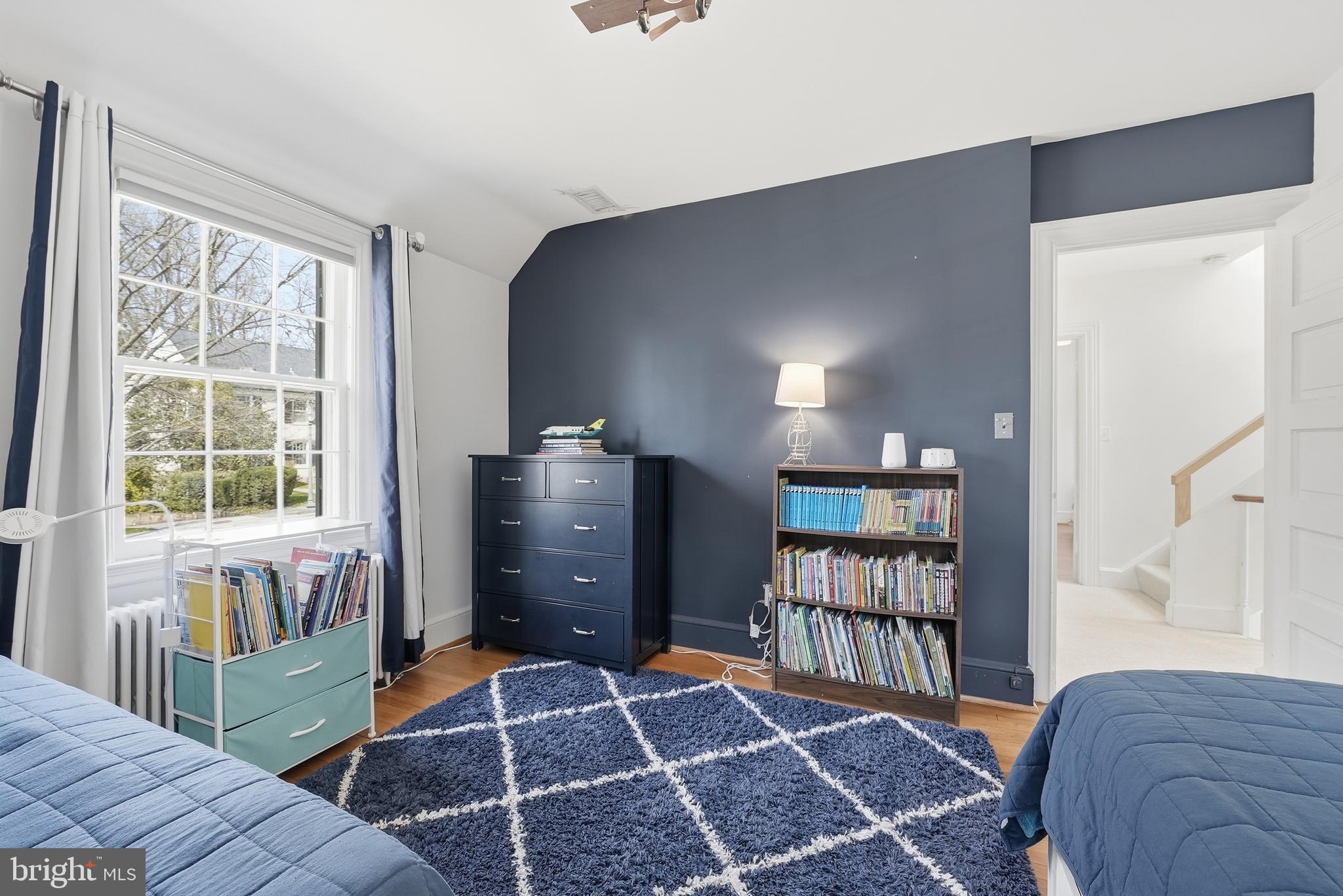4938 Quebec Street Northwest Washington, DC 20016 - Photo 33 of 51 a bedroom with a bed and a book shelf