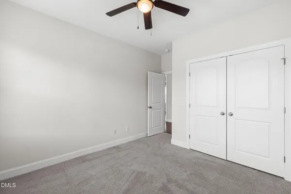 an empty room with chandelier fan