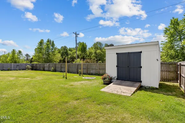 a backyard of a house with plants and wooden fence