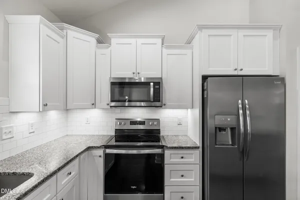 a kitchen with white cabinets and stainless steel appliances