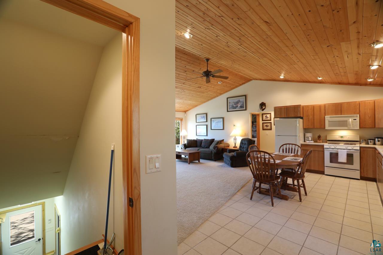 1880 Everett Bay Road Tower, MN 55790 - Photo 35 of 50 Dining space with vaulted ceiling, wooden ceiling, a ceiling fan, light carpet, and light tile patterned floors