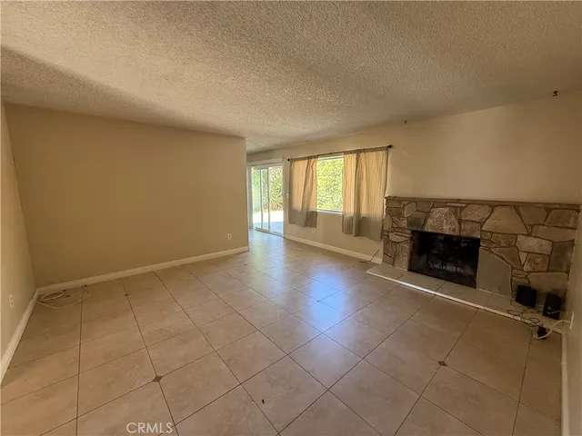 an empty room with fireplace and windows