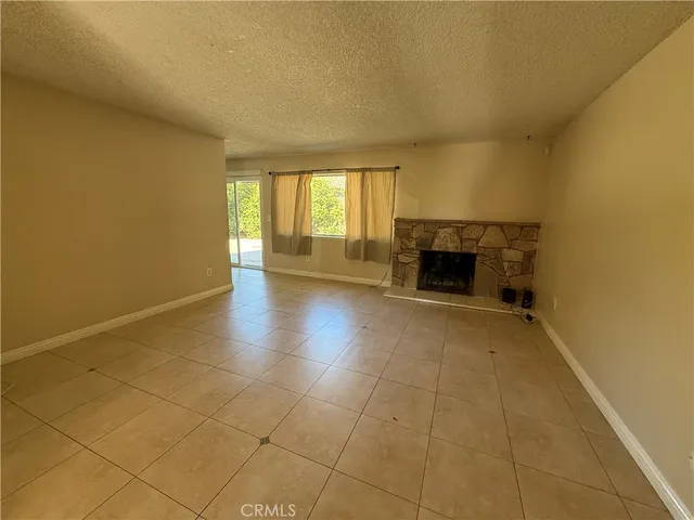 an empty room with a fireplace and a window
