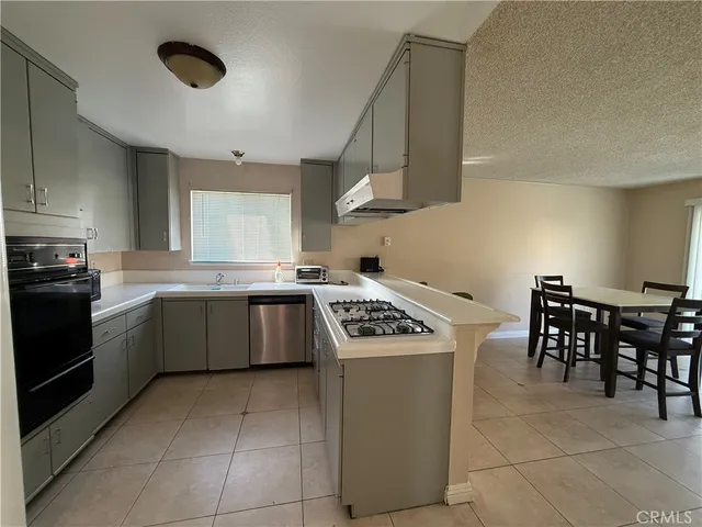 a kitchen with a stove sink and cabinets