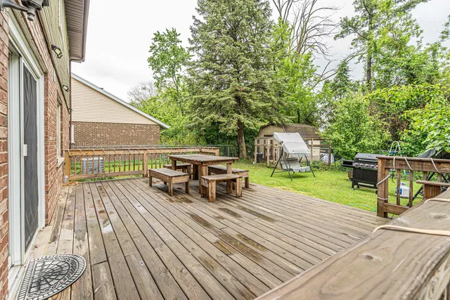 a view of a house with wooden deck and furniture