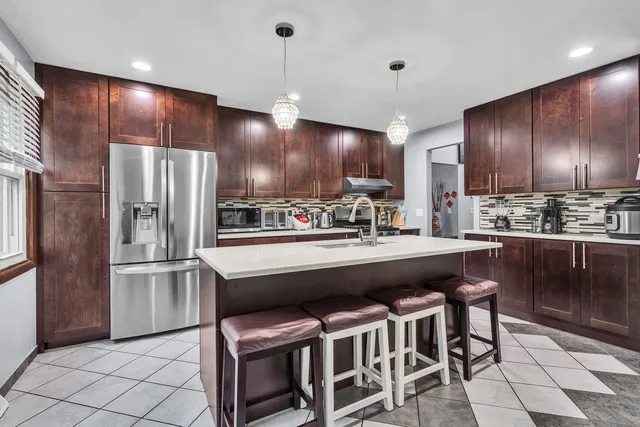 a kitchen with stainless steel appliances granite countertop a sink refrigerator and cabinets