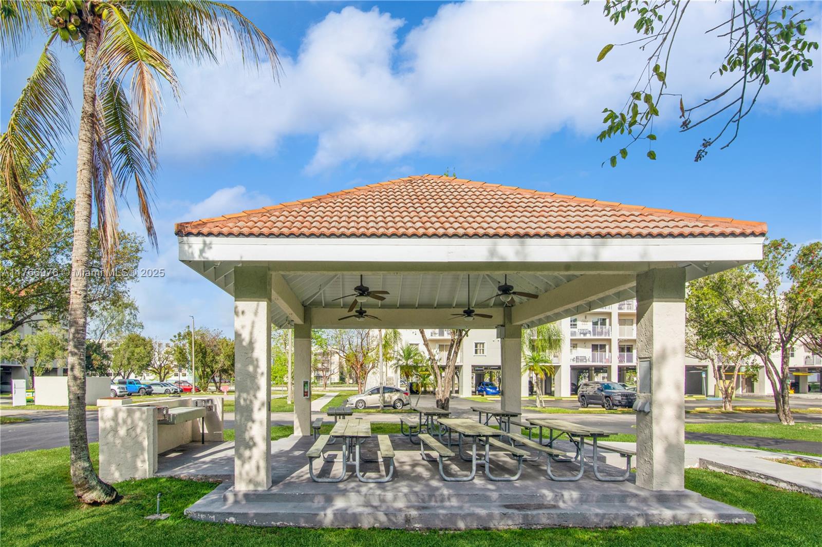 8200 Southwest 210th Street, Unit 111 Cutler Bay, FL 33189 - Photo 11 of 23 a view of a patio with table and chairs potted plants and palm trees