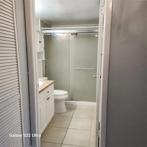 a bathroom with a granite countertop shower and a toilet